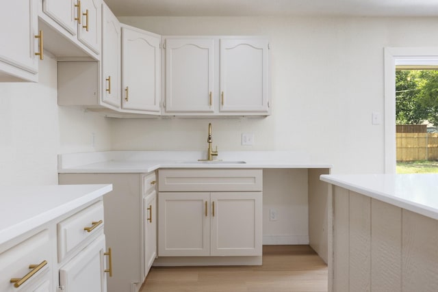 719 Sara Dr, Mesquite, TX 75149 - kitchen featuring light wood-style flooring, light countertops, and white cabinets