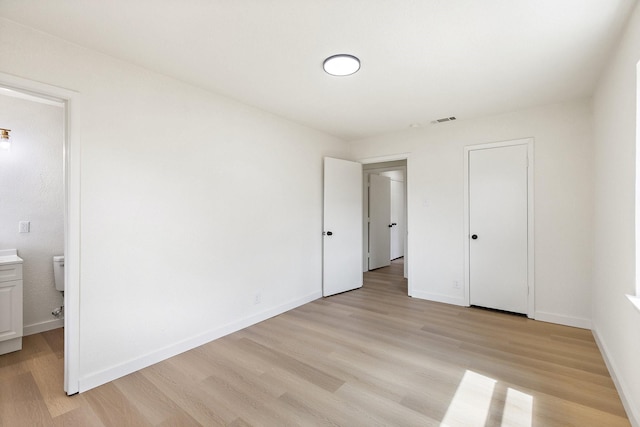 719 Sara Dr, Mesquite, TX 75149 - unfurnished bedroom featuring light wood finished floors and ensuite bathroom