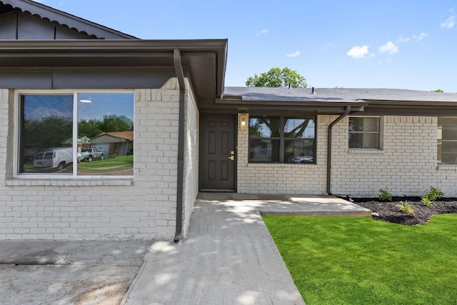 719 Sara Dr, Mesquite, TX 75149 - view of exterior entry with brick siding and a lawn
