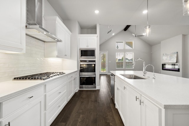 13313 Rembrandt Dr, Frisco, TX 75035 - kitchen with wall chimney range hood, stainless steel appliances, dark wood finished floors, white cabinetry, and decorative backsplash
