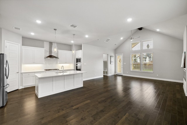 13313 Rembrandt Dr, Frisco, TX 75035 - kitchen featuring wall chimney exhaust hood, appliances with stainless steel finishes, ceiling fan, open floor plan, and dark wood finished floors
