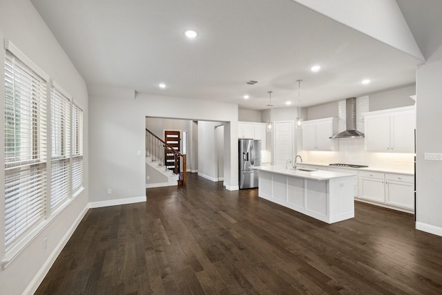 13313 Rembrandt Dr, Frisco, TX 75035 - kitchen with wall chimney exhaust hood, stainless steel fridge with ice dispenser, a kitchen island with sink, backsplash, and dark wood-style flooring