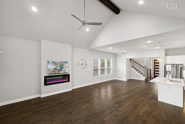 13313 Rembrandt Dr, Frisco, TX 75035 - unfurnished living room with stairs, a glass covered fireplace, high vaulted ceiling, ceiling fan, and beamed ceiling