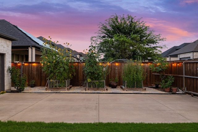 13313 Rembrandt Dr, Frisco, TX 75035 - patio terrace at dusk with a patio area, a fenced backyard, and a garden