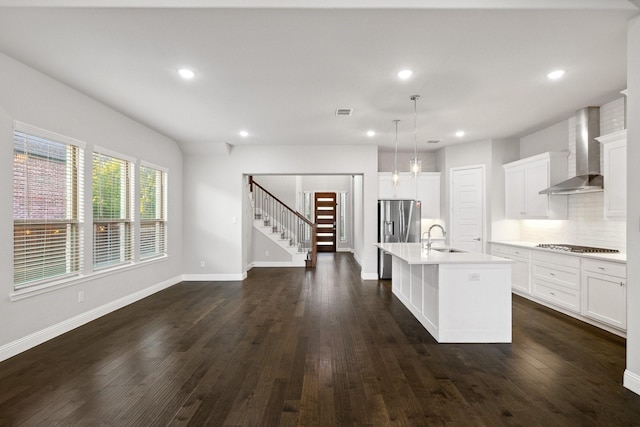 13313 Rembrandt Dr, Frisco, TX 75035 - kitchen with wall chimney exhaust hood, stainless steel fridge with ice dispenser, a kitchen island with sink, tasteful backsplash, and light countertops