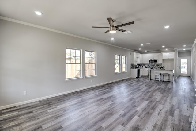 205 John Fielder, Sherman, TX 75092 - unfurnished living room with recessed lighting, ornamental molding, ceiling fan, plenty of natural light, and wood finished floors