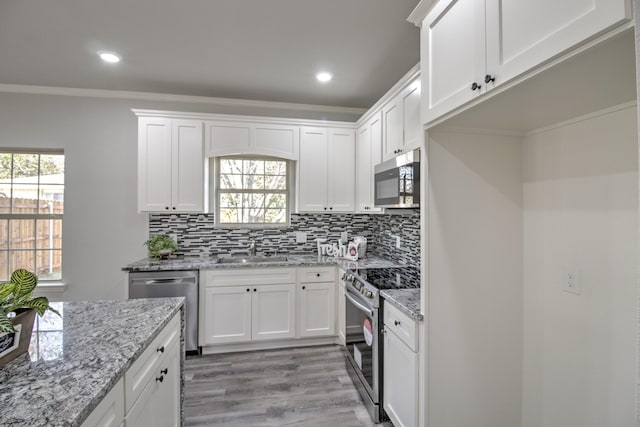 205 John Fielder, Sherman, TX 75092 - kitchen with stainless steel appliances, crown molding, light wood-type flooring, white cabinets, and decorative backsplash