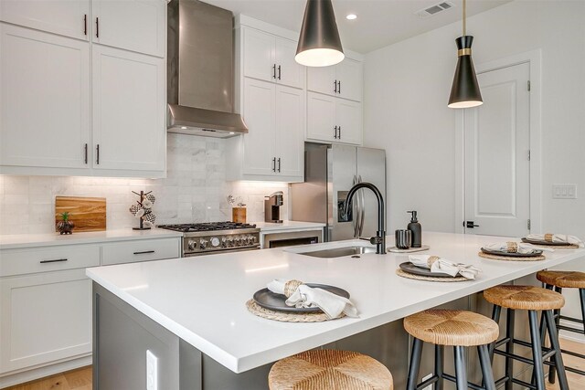 123 Thornton St, Arlington, TX 76013 - kitchen with wall chimney range hood, appliances with stainless steel finishes, an island with sink, tasteful backsplash, and recessed lighting