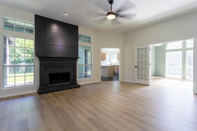 1526 Shadow Run, Weatherford, TX 76086 - unfurnished living room with light wood-style floors, a brick fireplace, healthy amount of natural light, a ceiling fan, and recessed lighting