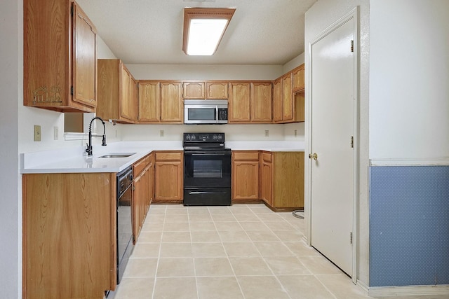534 Gettysburg St, Mesquite, TX 75149 - kitchen with black appliances, brown cabinets, light countertops, and light tile patterned flooring
