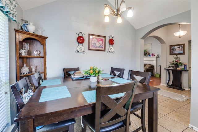 5615 Wellston Dr, Arlington, TX 76018 - dining room with vaulted ceiling, arched walkways, light tile patterned floors, and a chandelier