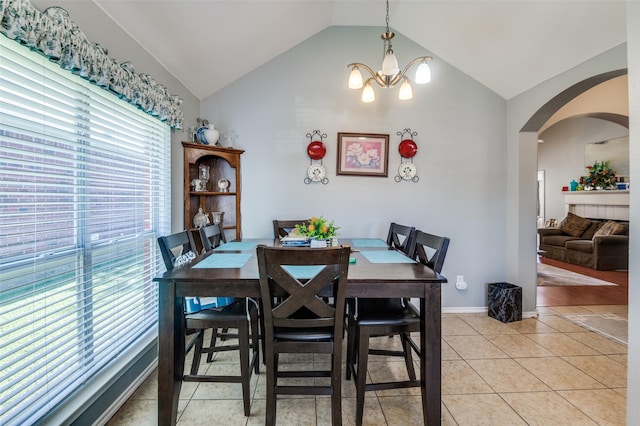 5615 Wellston Dr, Arlington, TX 76018 - dining area featuring lofted ceiling, arched walkways, a chandelier, and light tile patterned floors