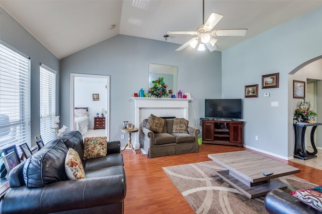 5615 Wellston Dr, Arlington, TX 76018 - living room with arched walkways, lofted ceiling, a ceiling fan, wood finished floors, and a tiled fireplace