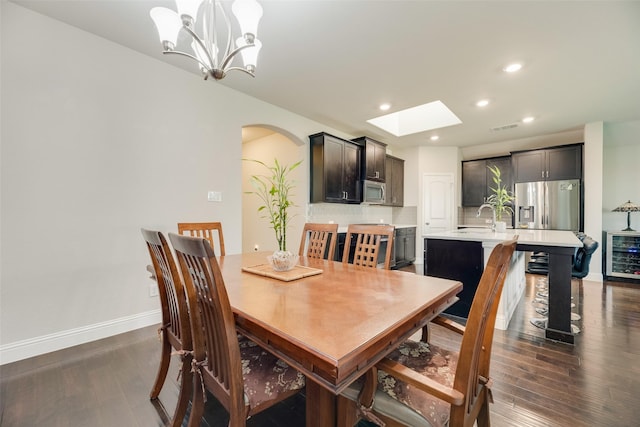 6159 Allatoona Rd, Fort Worth, TX 76179 - dining space with arched walkways, dark wood-type flooring, beverage cooler, recessed lighting, and a skylight