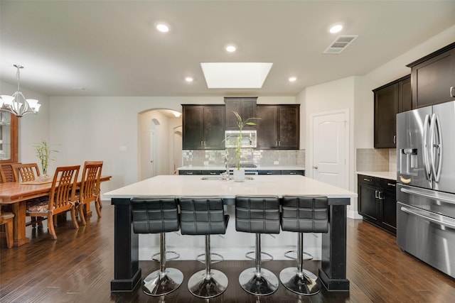 6159 Allatoona Rd, Fort Worth, TX 76179 - kitchen with stainless steel fridge, arched walkways, a breakfast bar area, light countertops, and recessed lighting