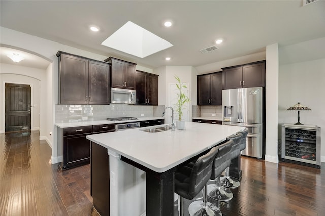 6159 Allatoona Rd, Fort Worth, TX 76179 - kitchen featuring stainless steel appliances, beverage cooler, dark brown cabinets, dark wood finished floors, and tasteful backsplash