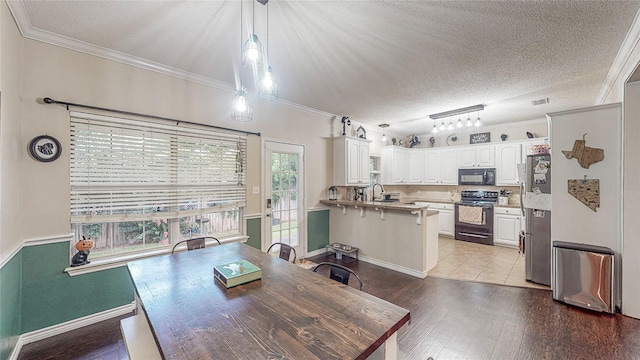 114 Bluebird Ln, Whitehouse, TX 75791 - dining area featuring light wood-type flooring, crown molding, and a textured ceiling