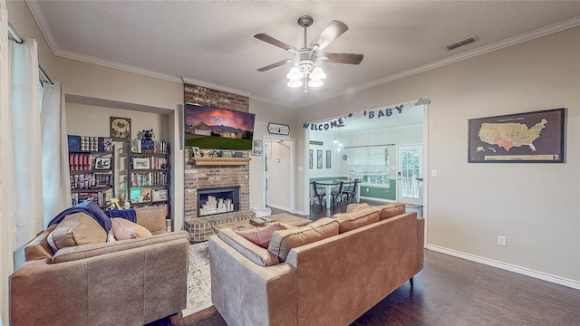 114 Bluebird Ln, Whitehouse, TX 75791 - living room featuring a fireplace, dark wood-style flooring, ceiling fan, ornamental molding, and a textured ceiling