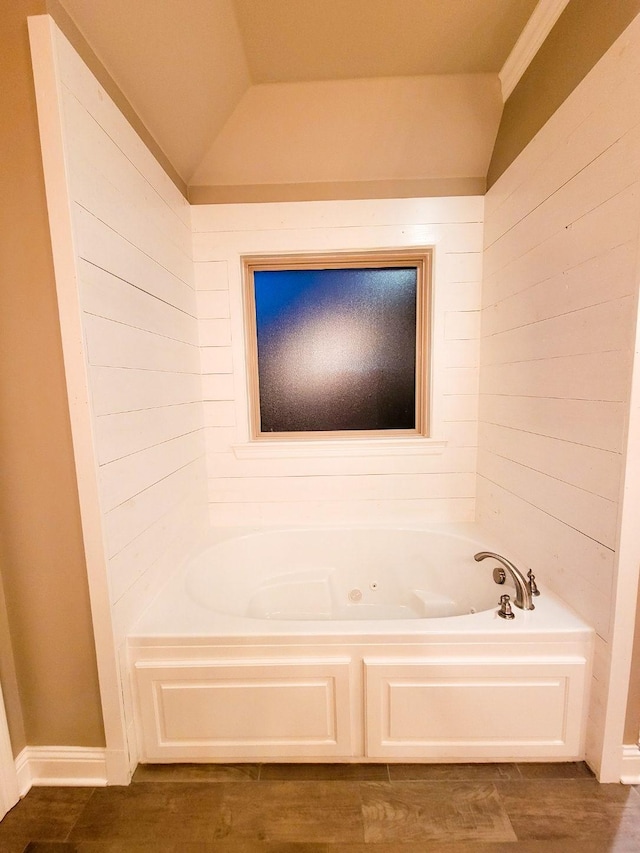 104 St Andrews Ln, Benton, LA 71006 - bathroom with a jetted tub, wood finished floors, wood walls, and vaulted ceiling