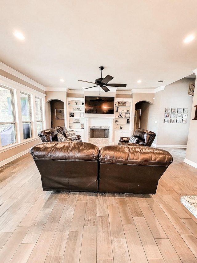 104 St Andrews Ln, Benton, LA 71006 - living area featuring arched walkways, a ceiling fan, ornamental molding, a premium fireplace, and light wood-type flooring