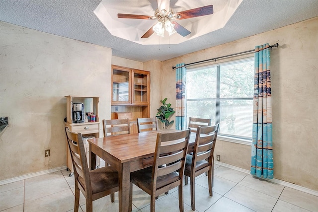 6824 Ridgewood Dr, North Richland Hills, TX 76182 - dining room with a textured ceiling, light tile patterned floors, a ceiling fan, and a tray ceiling