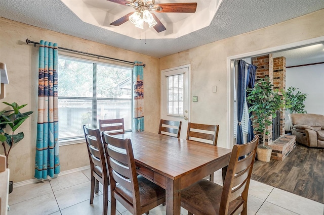 6824 Ridgewood Dr, North Richland Hills, TX 76182 - dining room with plenty of natural light, ceiling fan, light tile patterned flooring, a raised ceiling, and a textured ceiling