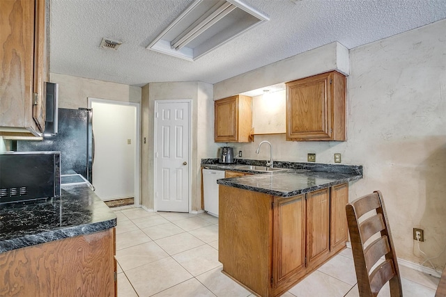 6824 Ridgewood Dr, North Richland Hills, TX 76182 - kitchen featuring black appliances, a peninsula, brown cabinetry, a textured ceiling, and light tile patterned floors