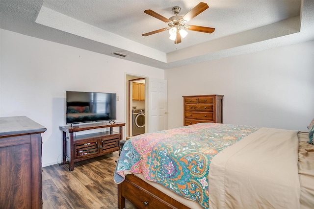 6824 Ridgewood Dr, North Richland Hills, TX 76182 - bedroom with washer / clothes dryer, wood finished floors, a raised ceiling, ceiling fan, and a textured ceiling