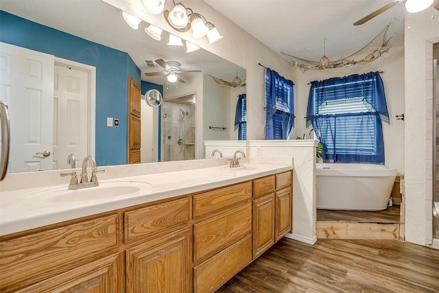 6824 Ridgewood Dr, North Richland Hills, TX 76182 - bathroom featuring a ceiling fan, a stall shower, a soaking tub, and double vanity