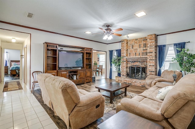 6824 Ridgewood Dr, North Richland Hills, TX 76182 - living area featuring plenty of natural light, ceiling fan, a fireplace, ornamental molding, and a textured ceiling