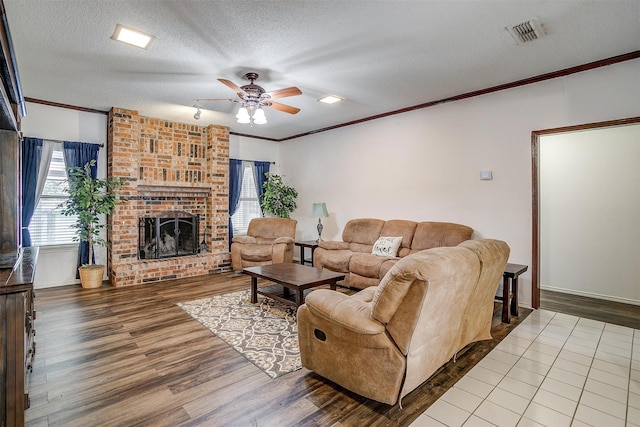 6824 Ridgewood Dr, North Richland Hills, TX 76182 - living room featuring plenty of natural light, ceiling fan, crown molding, wood finished floors, and a fireplace