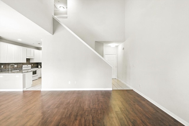 921 Englewood Ln, Plano, TX 75025 - unfurnished living room with light wood-style floors, stairs, and a high ceiling