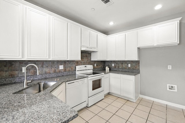 921 Englewood Ln, Plano, TX 75025 - kitchen with white appliances, under cabinet range hood, dark stone countertops, light tile patterned floors, and tasteful backsplash