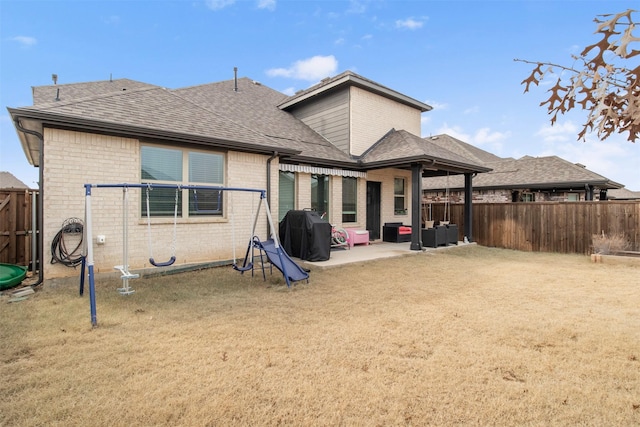 6205 Kent Ln, Celina, TX 76227 - rear view of property featuring a shingled roof, brick siding, a fenced backyard, and a patio