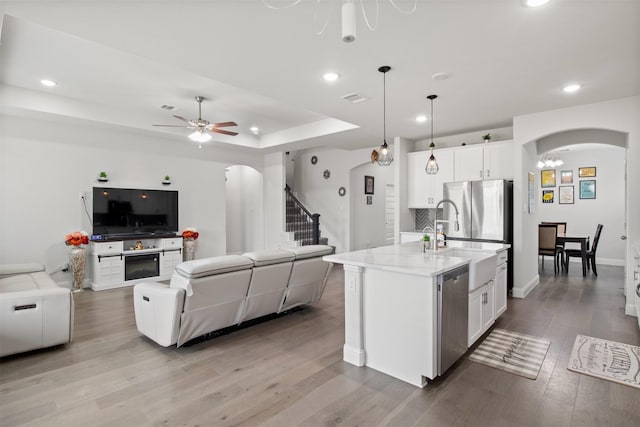 6205 Kent Ln, Celina, TX 76227 - kitchen with arched walkways, appliances with stainless steel finishes, open floor plan, a ceiling fan, and recessed lighting
