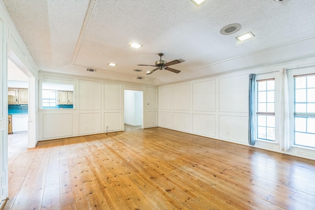1652 Ernie Ln, Grand Prairie, TX 75052 - spare room with a decorative wall, light wood-type flooring, healthy amount of natural light, a textured ceiling, and a ceiling fan