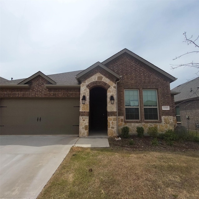 11305 Autry Ridge Ln, Aubrey, TX 76227 - view of front facade featuring stone siding, brick siding, an attached garage, and driveway