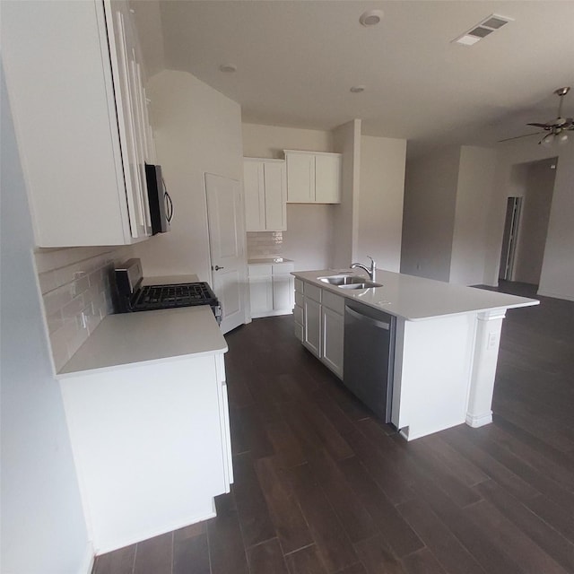 11305 Autry Ridge Ln, Aubrey, TX 76227 - kitchen with stainless steel appliances, dark wood-style flooring, a kitchen island with sink, decorative backsplash, and white cabinetry