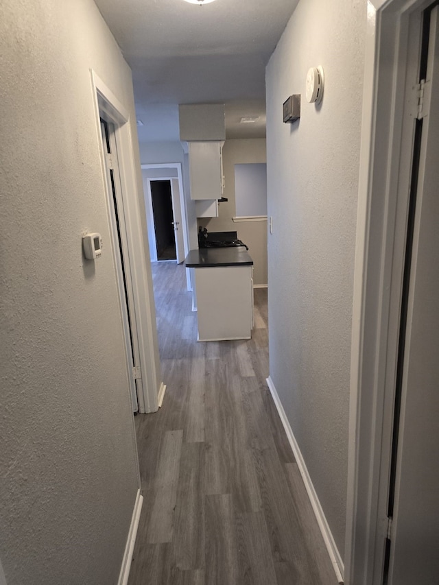 8916 Greenmound Ave, Dallas, TX 75227 - hallway featuring a textured wall and dark wood-style floors