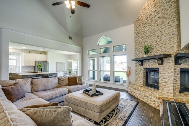 539 Curtiss Dr, Fate, TX 75087 - living area featuring a large fireplace, high vaulted ceiling, dark wood-style floors, a chandelier, and ceiling fan