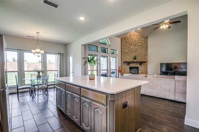 539 Curtiss Dr, Fate, TX 75087 - kitchen with a large fireplace, a ceiling fan, dark wood-type flooring, a center island, and light countertops