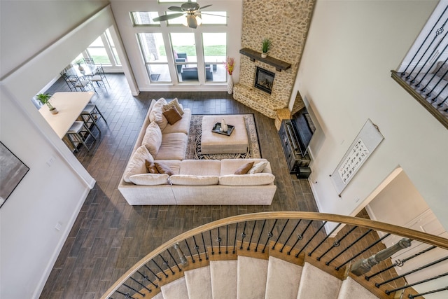 539 Curtiss Dr, Fate, TX 75087 - living room with a fireplace, ceiling fan, wood finished floors, stairway, and a high ceiling