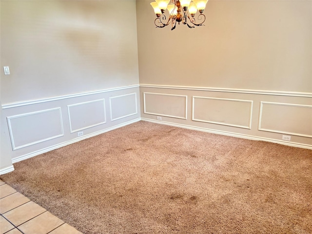 307 Forestridge Dr, Mansfield, TX 76063 - unfurnished room with a chandelier, a decorative wall, light carpet, wainscoting, and light tile patterned flooring