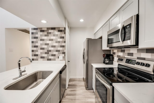 5750 Phoenix Dr Unit 39, Dallas, TX 75231 - kitchen featuring appliances with stainless steel finishes, tasteful backsplash, light wood-style floors, and recessed lighting