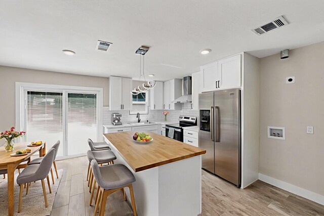5612 Meadow Nest Dr, Dallas, TX 75236 - kitchen with stainless steel appliances, wall chimney exhaust hood, wood counters, light wood-type flooring, and recessed lighting