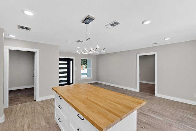 5612 Meadow Nest Dr, Dallas, TX 75236 - kitchen with butcher block countertops, white cabinetry, light wood-type flooring, decorative light fixtures, and recessed lighting