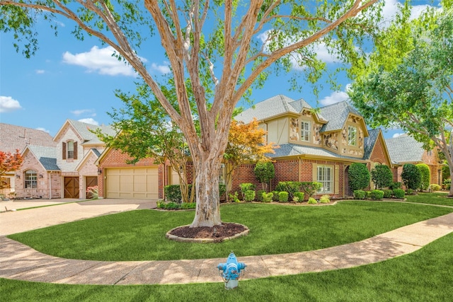 5701 Travis Dr, Frisco, TX 75034 - tudor home featuring driveway, a front lawn, brick siding, and a garage