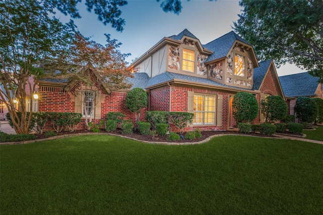 5701 Travis Dr, Frisco, TX 75034 - english style home featuring brick siding, a front lawn, and roof with shingles