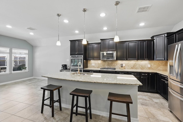 1129 Berrydale Dr, Northlake, TX 76226 - kitchen featuring appliances with stainless steel finishes, backsplash, a kitchen breakfast bar, a kitchen island with sink, and recessed lighting