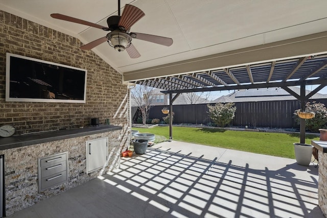 1129 Berrydale Dr, Northlake, TX 76226 - fenced backyard featuring a pergola, a ceiling fan, a patio area, and exterior kitchen